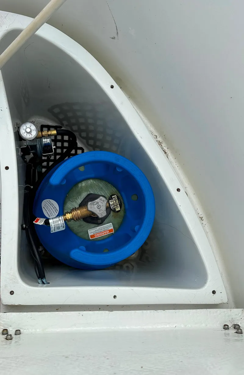 Slide: The Image of 1979 Valiant 37 boat compartment with blue propane tank and fittings. - 9