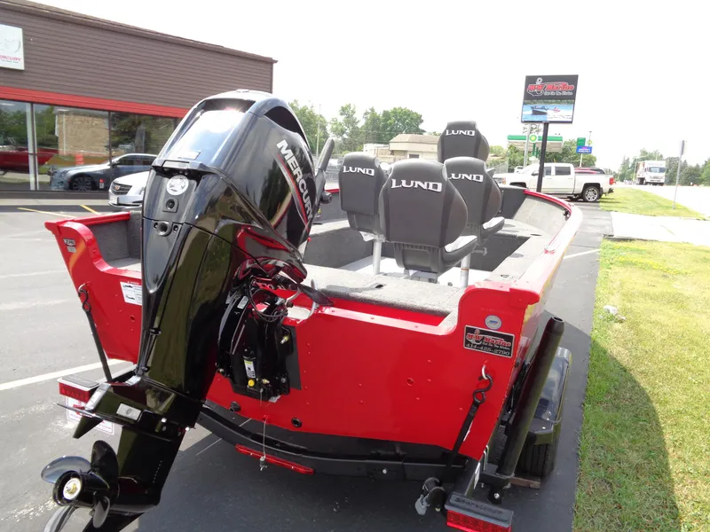 Slide: The Image of 2025 Lund 1650 Rebel XL Tiller boat with Mercury engine, parked outdoors. - 5