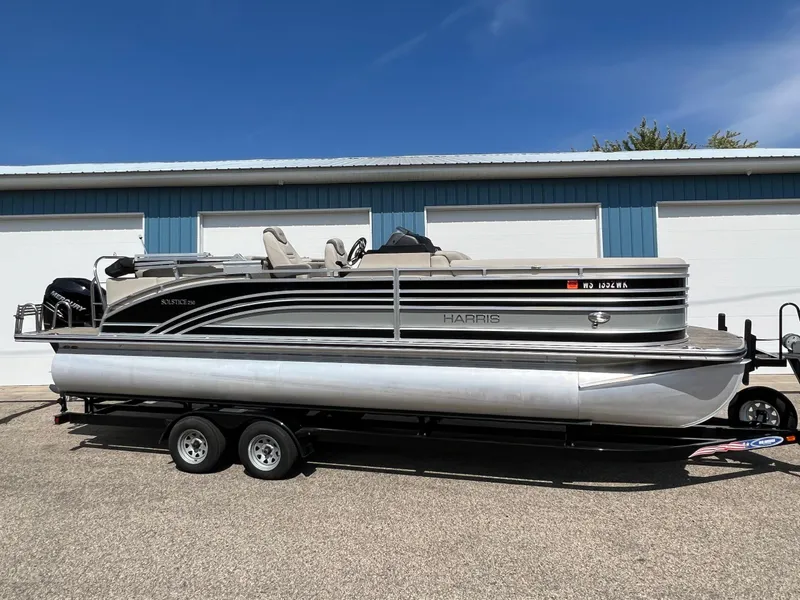 Slide: The Image of 2020 Harris FloteBote H SOL 250 CWDH TT pontoon boat on trailer, parked outdoors. - 1
