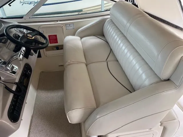 Slide: The Image of 2001 Cruisers Yachts 3470 Express helm with white leather seating and steering wheel. - 10