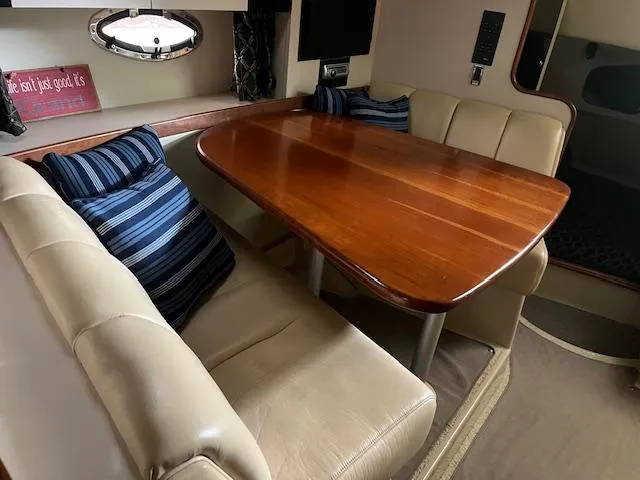 Slide: The Image of 2001 Cruisers Yachts 3470 Express interior with wooden table and beige seating. - 17