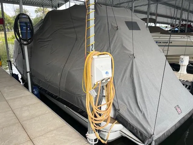 Slide: The Image of 2001 Cruisers Yachts 3470 Express covered in marina, docked with protective tarp. - 4