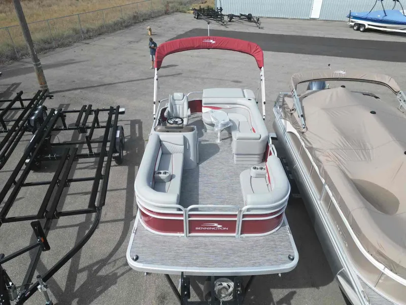 Slide: The Image of 2024 Bennington 20 SVL pontoon boat with red canopy, docked in a marina. - 3