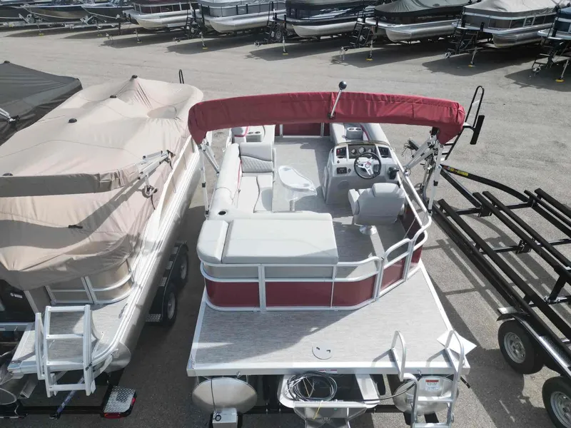 Slide: The Image of 2024 Bennington 20 SVL pontoon boat with red canopy, parked in a marina. - 5
