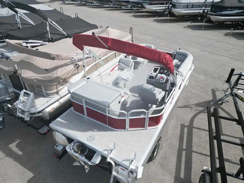 Slide: The Image of 2024 Bennington 20 SVL pontoon boat with red canopy, parked in a marina. - 6