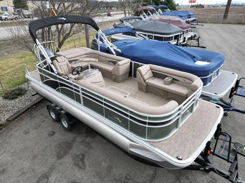 Slide: The Image of 2023 Bennington 22 SL pontoon boat with beige seating, parked on a trailer. - 4