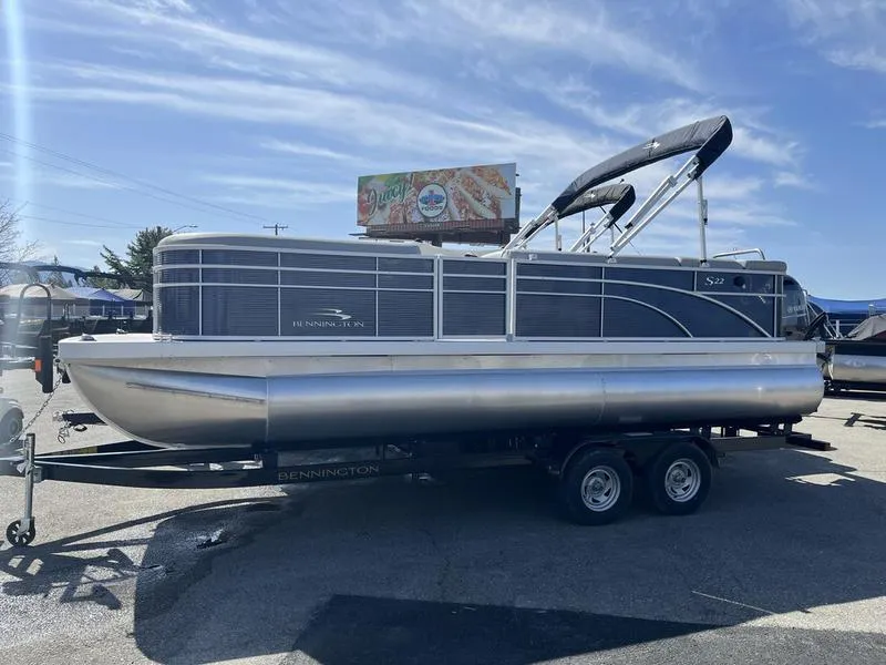 Slide: The Image of 2023 Bennington 22 SL pontoon boat on trailer under clear sky. - 1