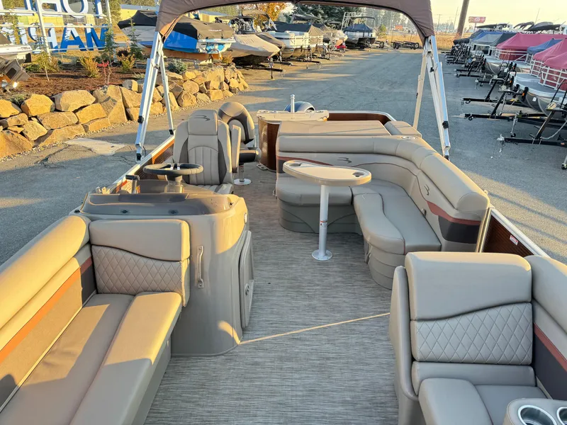 Slide: The Image of 2023 Bennington 22 SS pontoon boat with luxurious seating and helm, docked outdoors. - 4