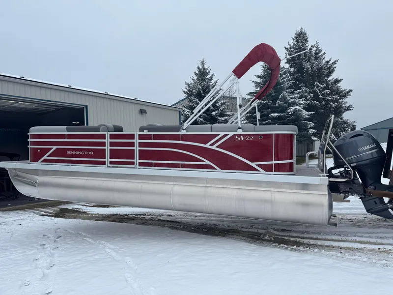 Slide: The Image of 2024 Bennington 22 SVL pontoon boat with Yamaha motor in snowy setting. - 2