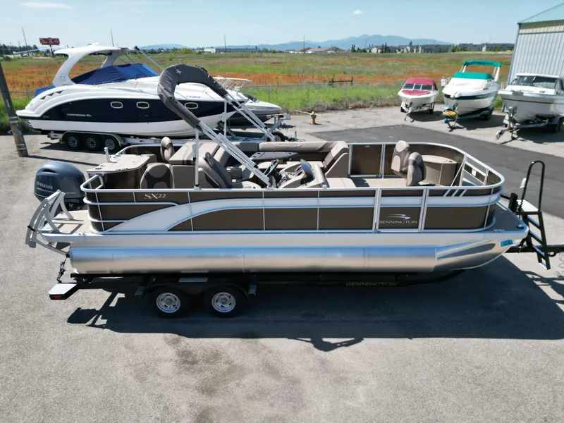 Slide: The Image of 2023 Bennington 22 SXFAPG pontoon boat on trailer, parked outdoors. - 4