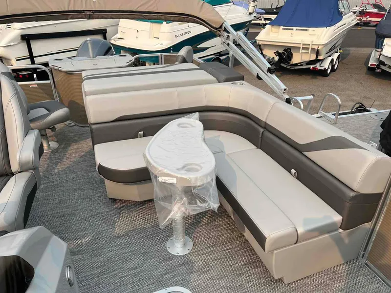 Slide: The Image of 2023 Bennington 22 SXSAPG pontoon boat interior with gray seating and table. - 11