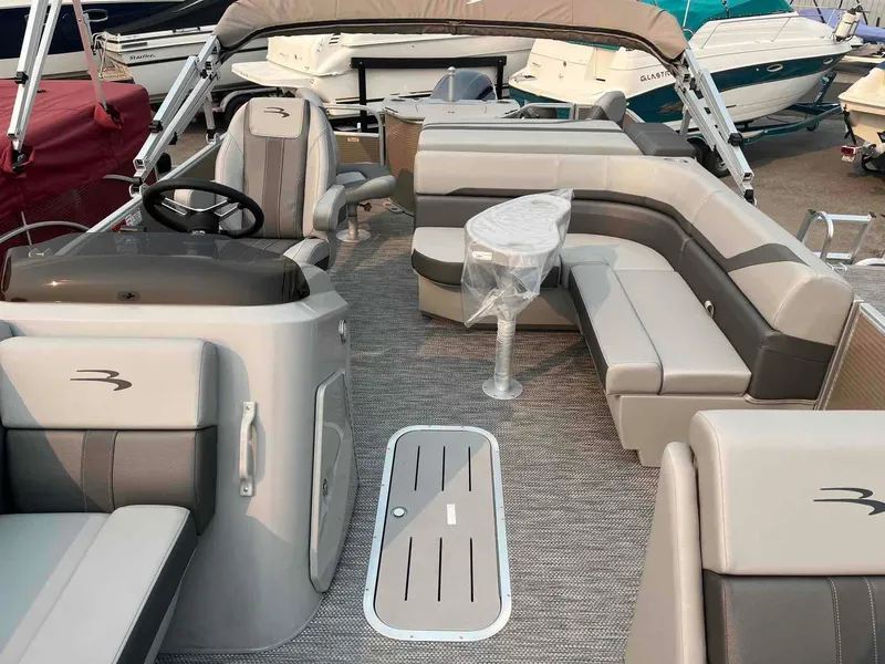 Slide: The Image of 2023 Bennington 22 SXSAPG pontoon boat interior with plush seating and helm. - 13