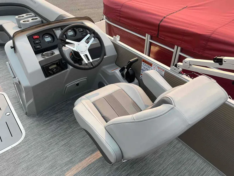 Slide: The Image of 2023 Bennington 22 SXSAPG boat helm with steering wheel and captain's chair. - 16
