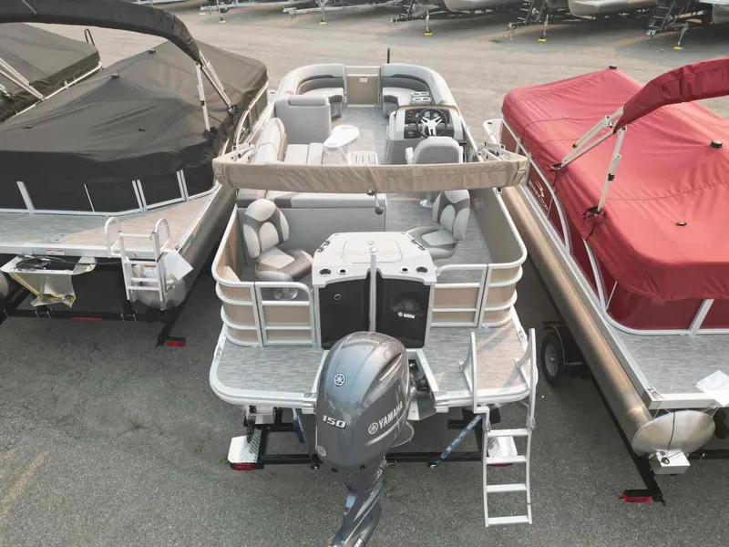 Slide: The Image of 2023 Bennington 22 SXSAPG pontoon boat with Yamaha engine, docked between covered boats. - 5