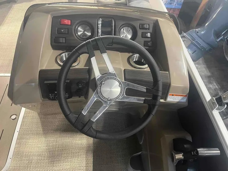 Slide: The Image of 2024 Bennington 22 SXSB boat dashboard with steering wheel and controls. - 15