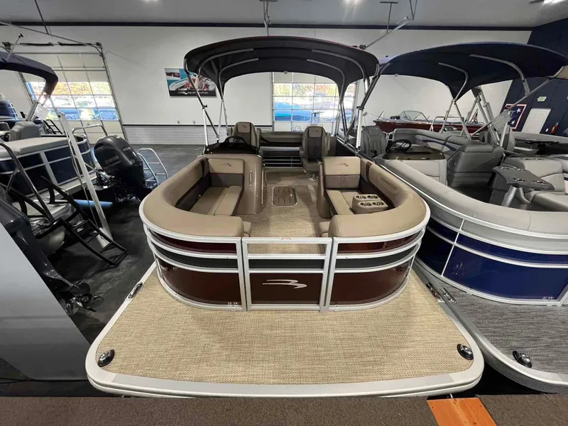 Slide: The Image of 2024 Bennington 22 SXSB pontoon boat in showroom, featuring spacious seating and modern design. - 2