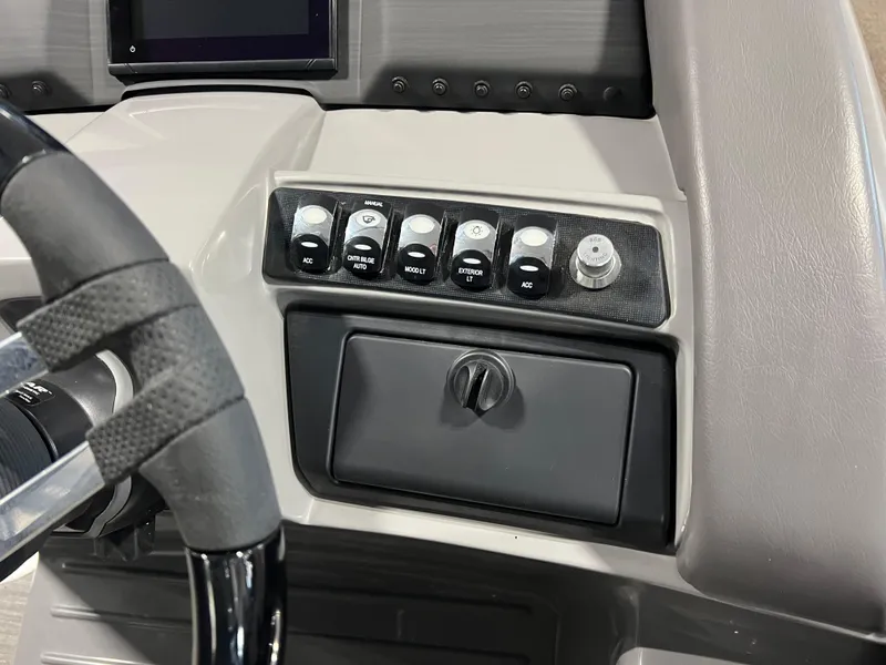 Slide: The Image of Dashboard controls of 2023 Bennington 23 LXFB boat, featuring steering wheel and switches. - 11