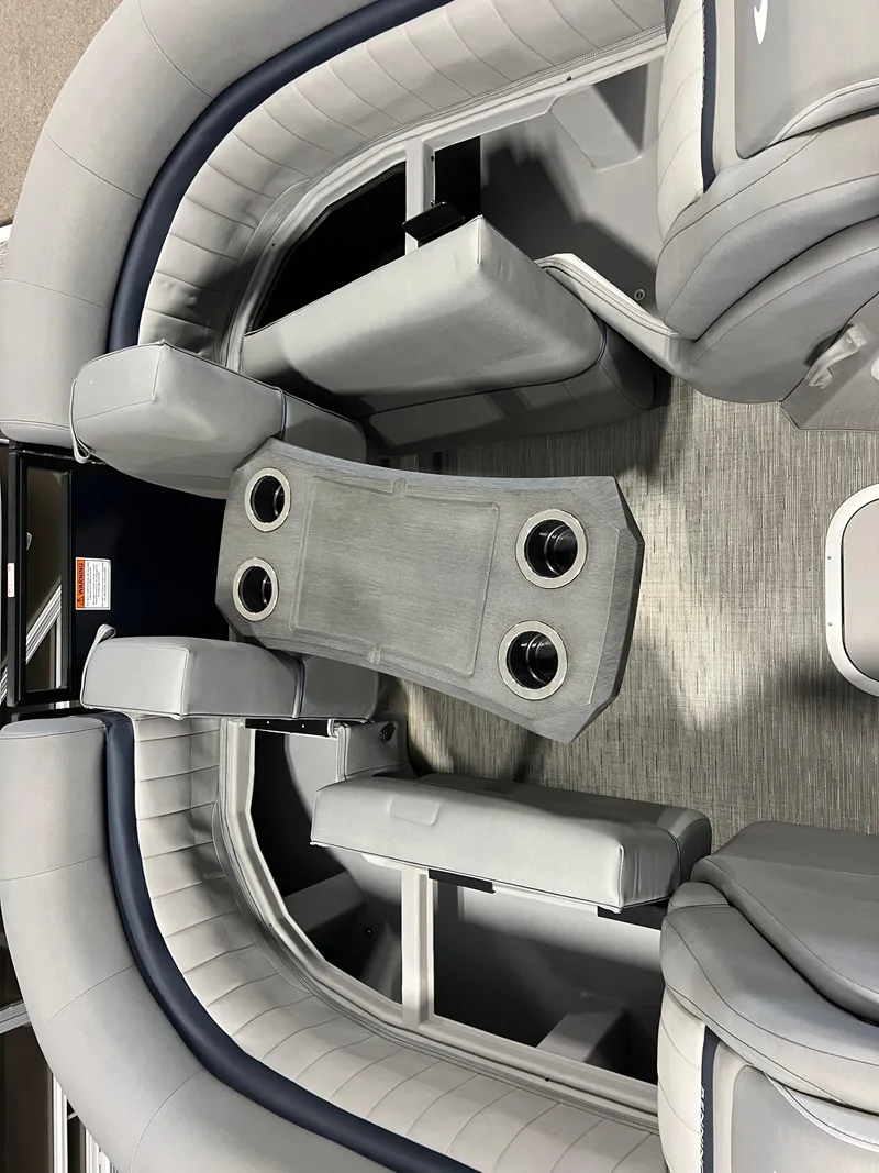 Slide: The Image of 2023 Bennington 23 LXFB boat interior with gray seating and table featuring cup holders. - 14