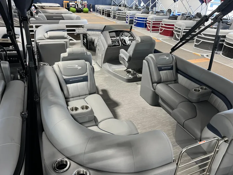Slide: The Image of 2023 Bennington 23 LXFB pontoon boat interior with luxurious gray seating and helm. - 18