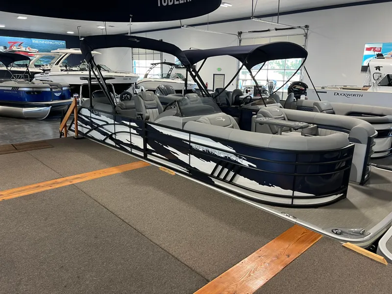 Slide: The Image of 2023 Bennington 23 LXFB pontoon boat displayed in a showroom. - 2