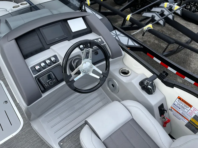 Slide: The Image of 2024 Bennington 24LXSFB boat dashboard with steering wheel and control panel. - 13