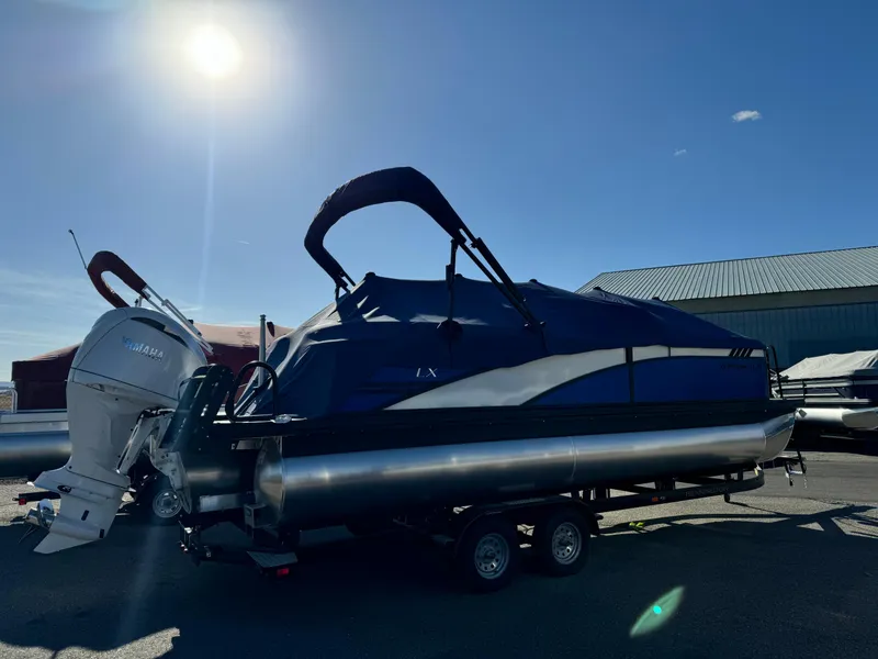 Slide: The Image of 2024 Bennington 24LXSFB pontoon boat with Yamaha engine, covered and on trailer. - 3