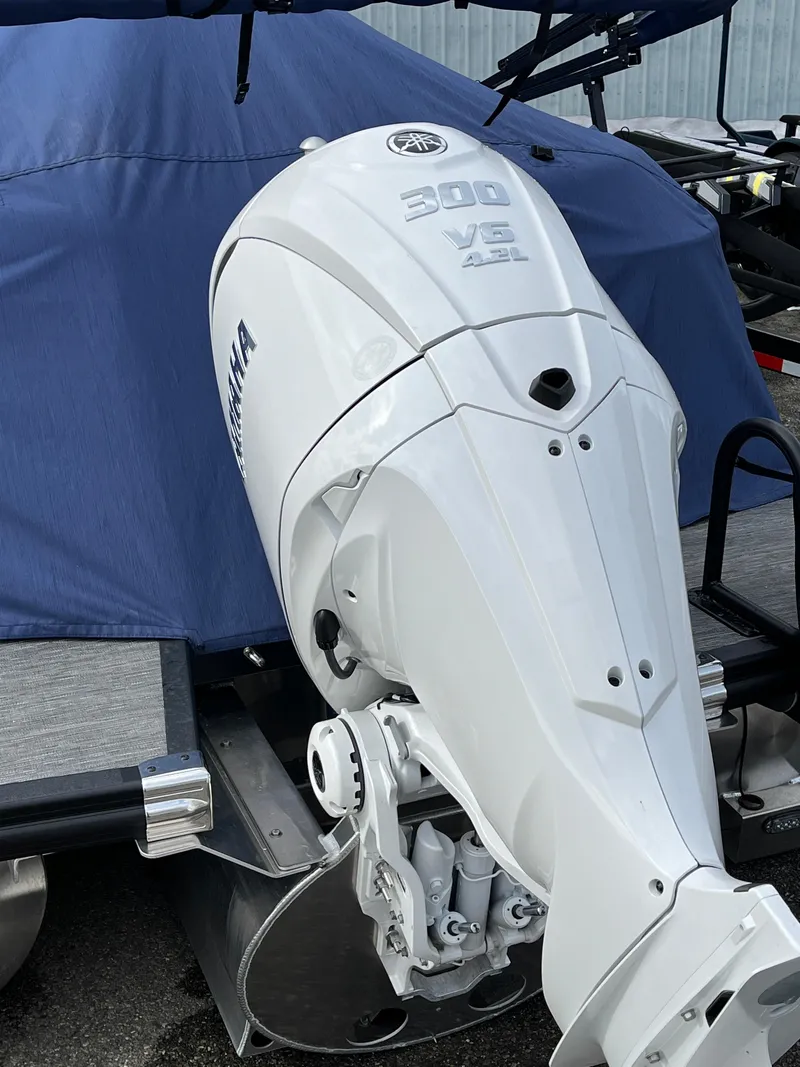 Slide: The Image of 2024 Bennington 24LXSFB with Yamaha 300 V6 outboard engine, covered in blue tarp. - 8