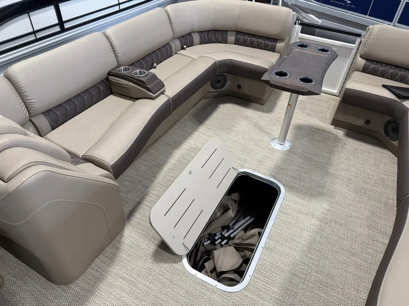 Slide: The Image of 2024 Bennington 28 QXFBAX1 boat interior with beige seating and storage compartment open. - 20