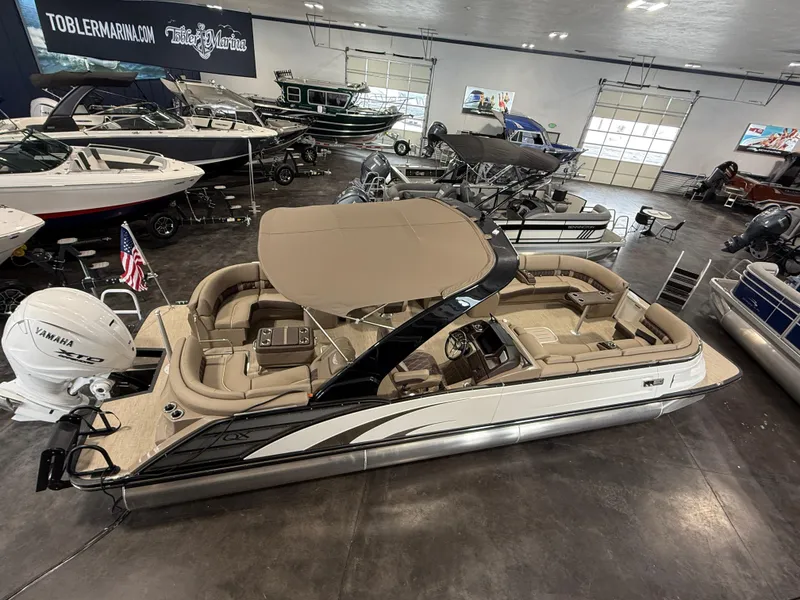 Slide: The Image of 2024 Bennington 28 QXFBAX1 pontoon boat displayed in a showroom with other boats. - 5