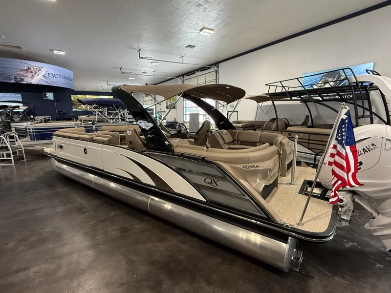 Slide: The Image of 2024 Bennington 28 QXFBAX1 pontoon boat displayed indoors with American flag. - 8