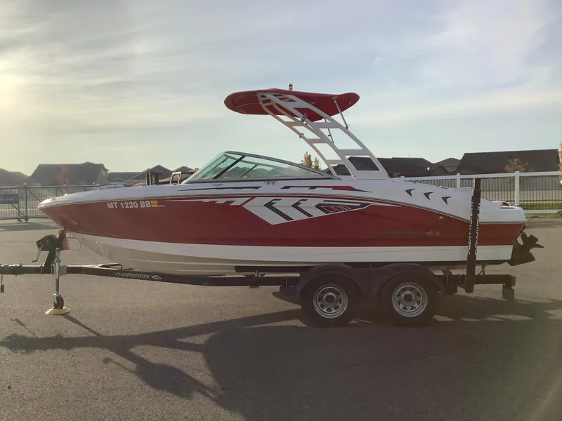 Slide: The Image of 2014 Chaparral 21 H2O boat on trailer, red and white design, parked outdoors. - 1
