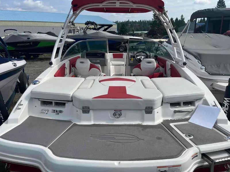 Slide: The Image of 2014 Chaparral 21 H2O boat with red and white interior, docked outdoors. - 12