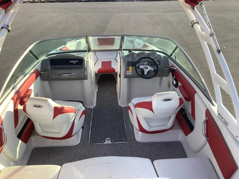 Slide: The Image of 2014 Chaparral 21 H2O boat interior with red and white seating, steering wheel, and dashboard. - 13