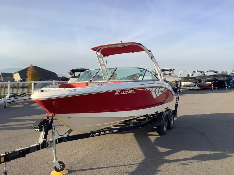 Slide: The Image of 2014 Chaparral 21 H2O boat in red on trailer, parked outdoors. - 2