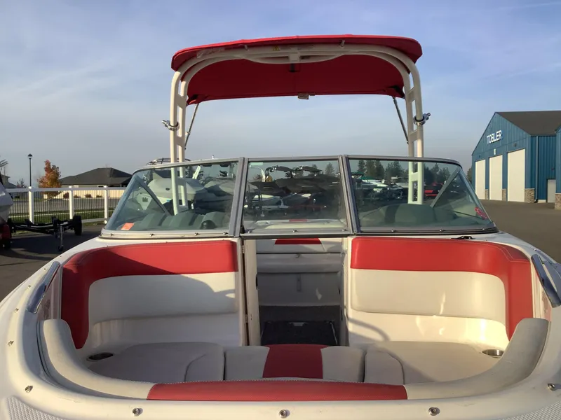 Slide: The Image of 2014 Chaparral 21 H2O boat with red and white interior, docked outdoors. - 5