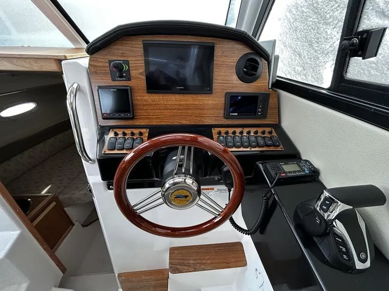 Slide: The Image of 2023 Cutwater C-248 C helm with wood paneling, steering wheel, and navigation controls. - 15