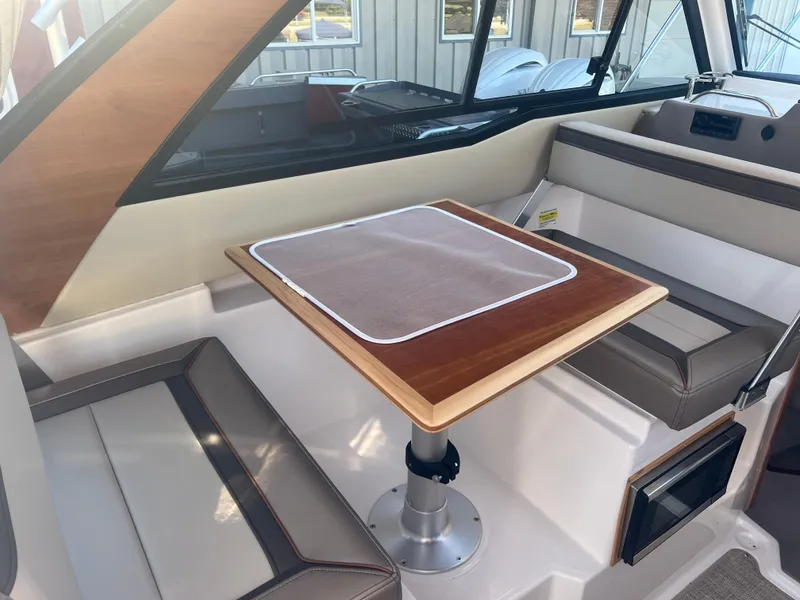 Slide: The Image of 2023 Cutwater C-248 C interior with wooden table and cushioned seating. - 28