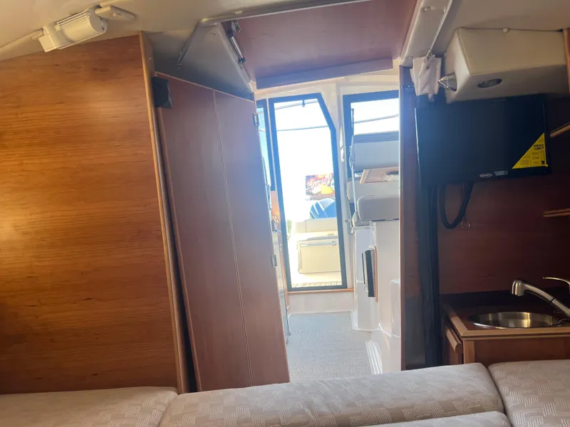 Slide: The Image of Interior view of 2023 Cutwater C-248 C boat, featuring wood paneling and compact amenities. - 39