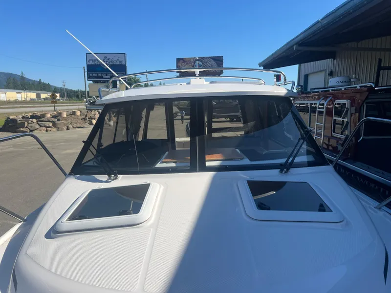 Slide: The Image of 2023 Cutwater C-248 C boat, front view, docked under clear blue sky. - 8