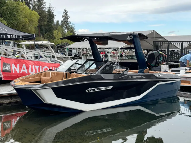 Slide: The Image of 2025 Nautique G23 boat docked at marina, featuring sleek design and modern amenities. - 1