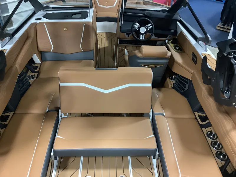 Slide: The Image of Luxurious interior of 2025 Nautique G23 boat with tan leather seating and modern dashboard. - 12