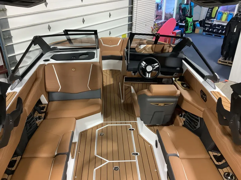 Slide: The Image of 2025 Nautique G23 boat interior with tan leather seats and sleek design. - 13