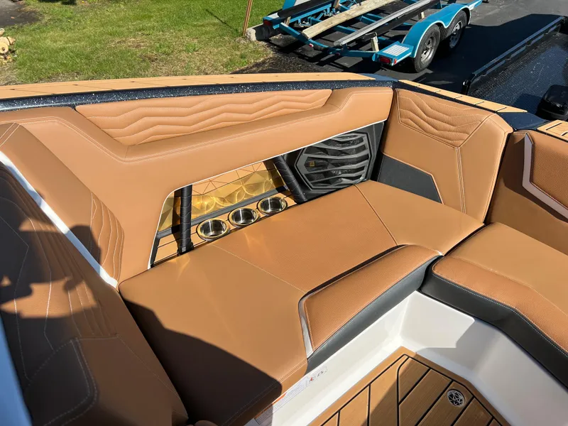 Slide: The Image of 2025 Nautique G23 boat interior with tan leather seating and cup holders. - 29