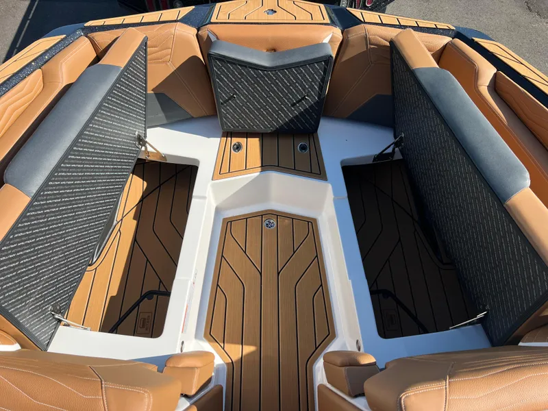 Slide: The Image of 2025 Nautique G23 boat interior with tan and gray seating, open storage compartments. - 32