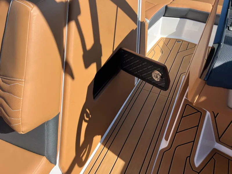 Slide: The Image of 2025 Nautique G23 interior with tan upholstery and sleek wood flooring. - 34