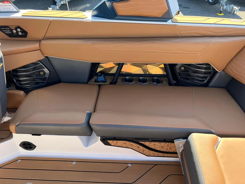 Slide: The Image of 2025 Nautique G23 boat interior with tan leather seating and cup holders. - 37