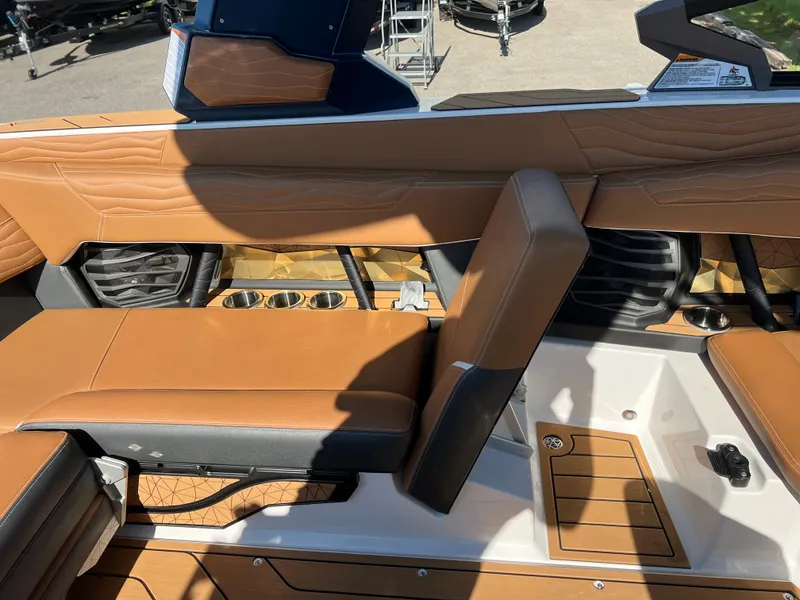 Slide: The Image of 2025 Nautique G23 boat interior with tan leather seats and cup holders. - 38