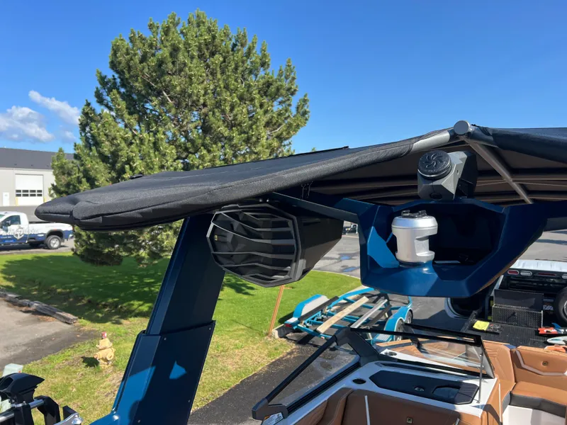 Slide: The Image of 2025 Nautique G23 boat with advanced audio system and canopy, parked outdoors. - 44