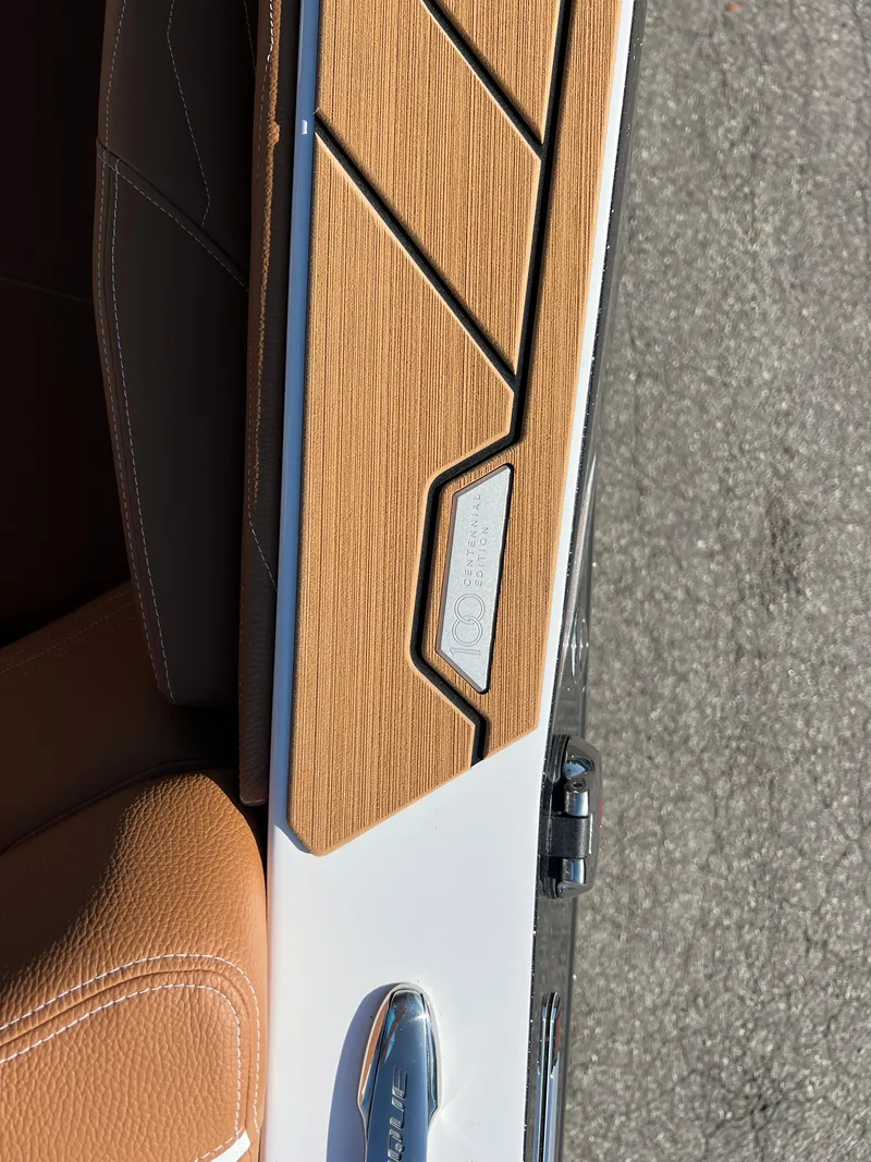 Slide: The Image of 2025 Nautique G23 boat interior with tan leather and wood accents. - 46