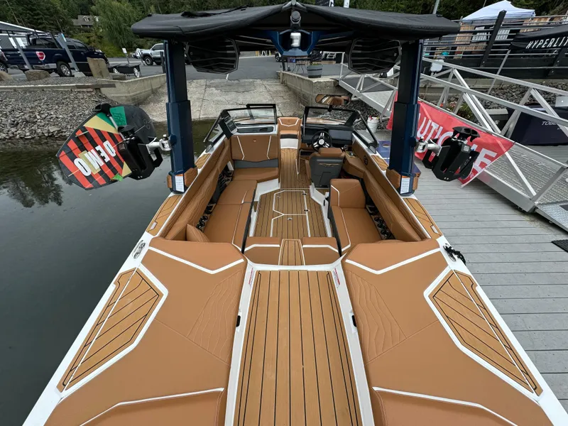 Slide: The Image of 2025 Nautique G23 boat with tan interior, docked at a marina. - 8